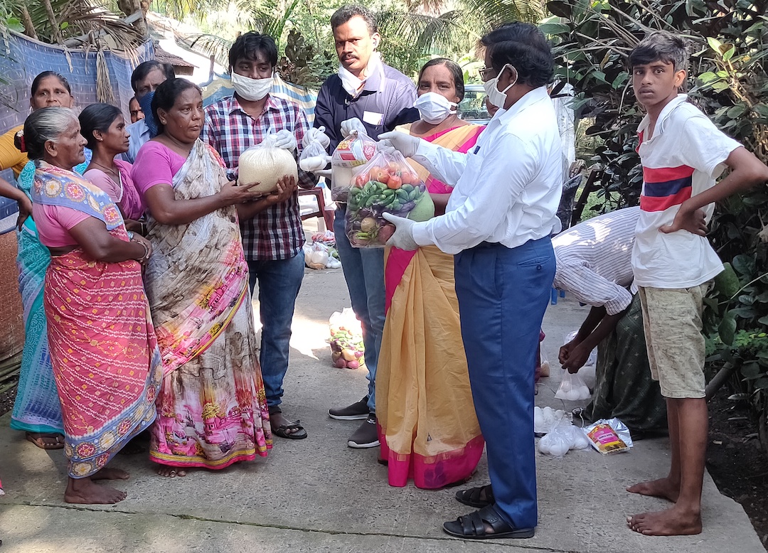 India - Pastor Raju and his wife Victoria, oversee the distribution of food to a village community.